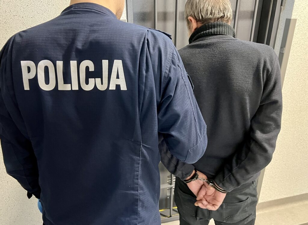 Policjant prowadzi zatrzymanego za kradzież zdrapek