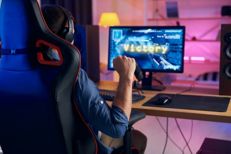 Sitting on the chair. Online streamer playing FPS shooter game at home.